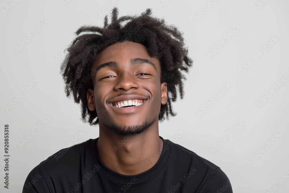 A handsome young man of African-American appearance close-up, with a wide smile, in a state of joy and delight, emotions, on a white background, medium shot. Advertising banner A handsome young man of African-American appearance close-up, with a wide smile, in a state of joy and delight, emotions, on a white background, medium shot. Advertising banner