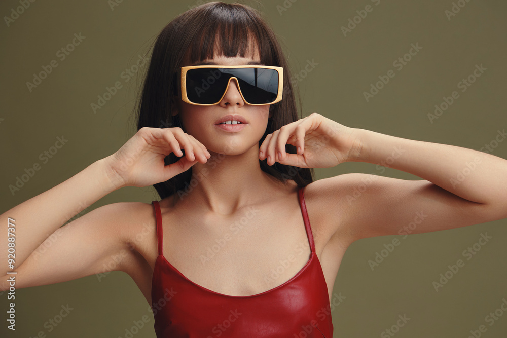 Woman, red dress, sunglasses a woman in a stylish red dress and chic sunglasses, with her hands on her head, looks directly at the camera, smiling confidently