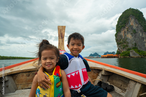 Adorable kids boy and girl travel sea island on wooden boat Phang nga island photo