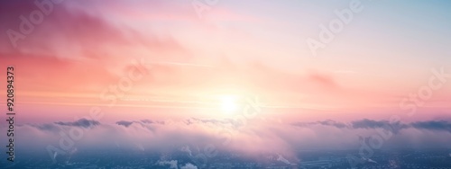  The sun illuminates the cityscape through pink and blue-tinted clouds in the sky