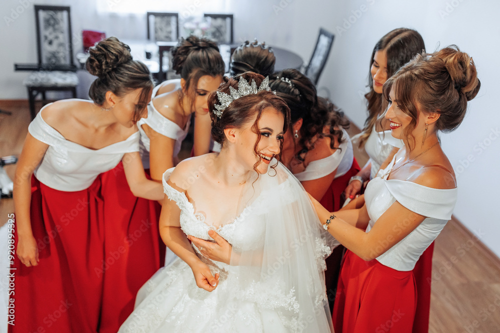 A bride is surrounded by her bridesmaids, all wearing red dresses A bride is surrounded by her bridesmaids, all wearing red dresses