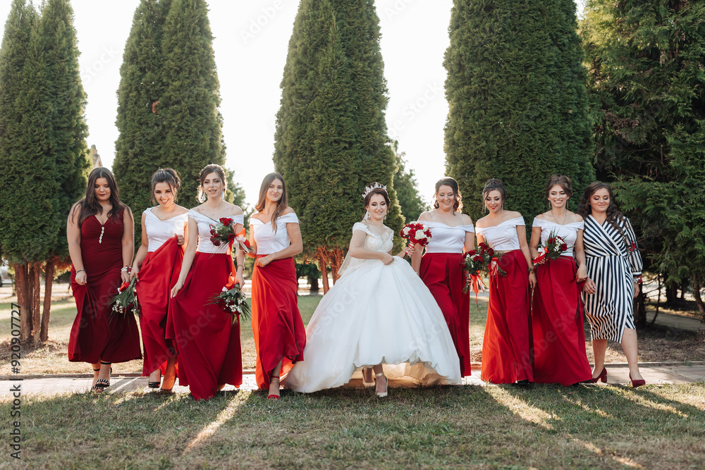 A group of women in red dresses are posing for a photo A group of women in red dresses are posing for a photo