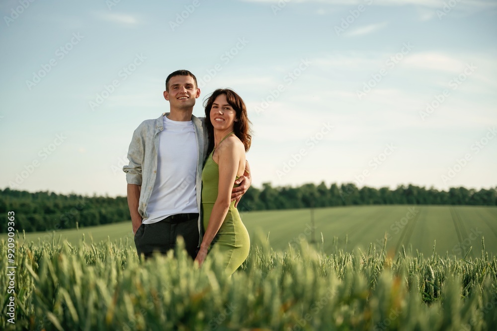 Standing and posing. Lovely couple are on the agricultural field together Standing and posing. Lovely couple are on the agricultural field together