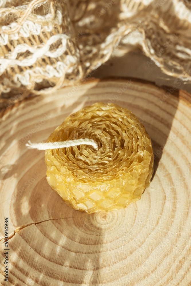 Handmade beautiful decorative candle of bee wax on pastel beige background.
