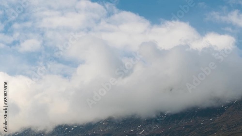 4K time lapse of rain clouds rolling over Seven Sister mountain peaks at Keylong in Lahaul, Himachal Pradesh, India. Dark monsoon clouds rolling over mountain peak. Scenic Nature landscape.  photo