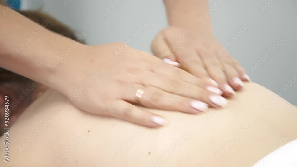 Close-up of a skilled massage therapist’s hands gently working on a young woman’s back. Ideal for promoting relaxation, wellness, and professional massage services. Close-up of a skilled massage therapist’s hands gently working on a young woman’s back. Ideal for promoting relaxation, wellness, and professional massage services.