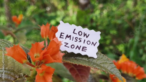 Low emission zone text warning signage isolated with a blurred green natural background to reduce carbon gas emissions polluting the environment and nature. Co2 neutral and decarbonisation concept. photo