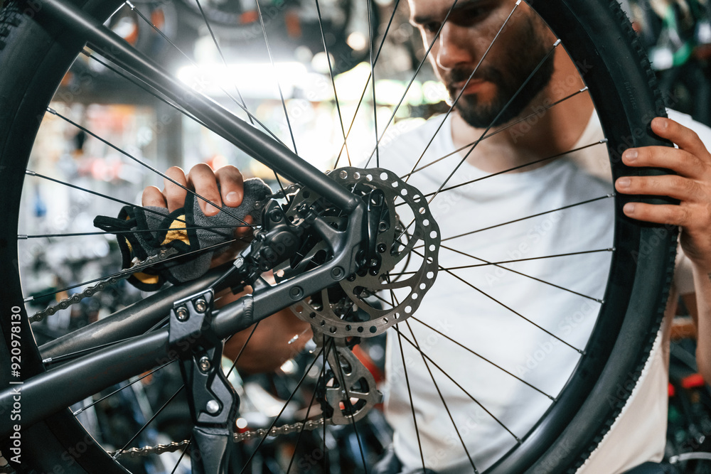 Obraz premium Cleaning the chain. Repair man in bicycle shop, working in store
