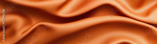 Elegant orange fabric with smooth, flowing waves creates a luxurious and soft texture that is perfect for backgrounds, textiles, or design projects. photo