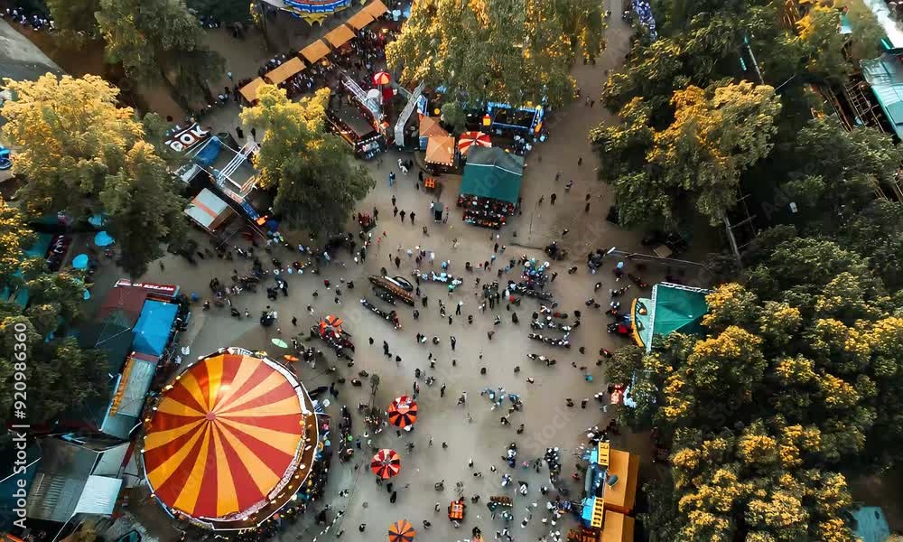 Aerial View of a Bustling Carnival: An overhead perspective captures the vibrant energy of a carnival, showcasing a colorful carousel surrounded by bustling crowds 