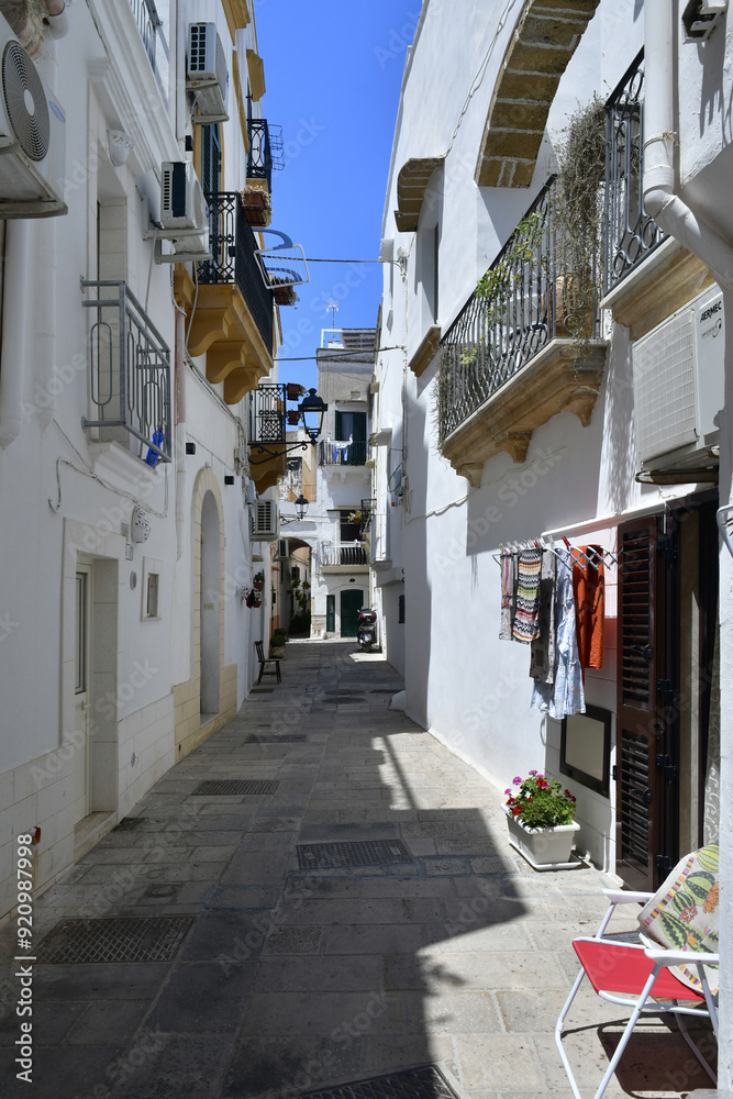 Obraz premium A narrow street in the historic center of Gallipoli, a tourist town in Puglia in Italy.