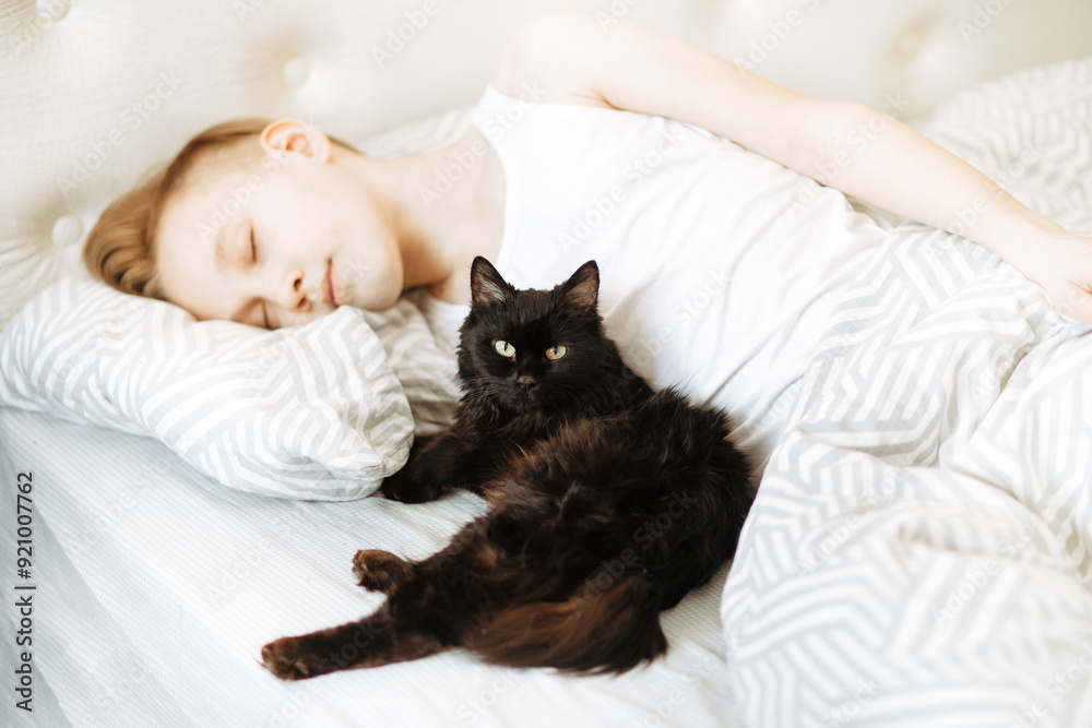 Kid boy teenager sleep on bed with best friend pet black cat Kid boy teenager sleep on bed with best friend pet black cat