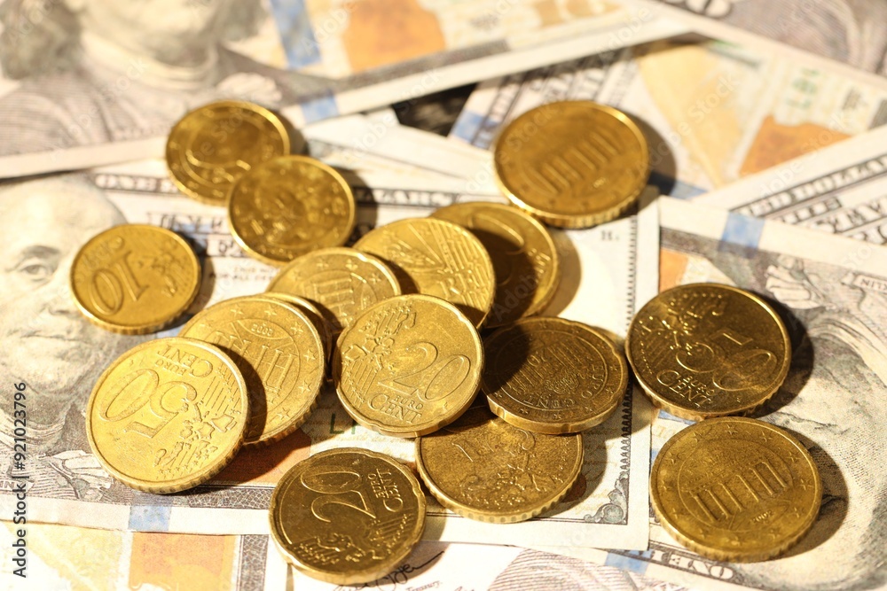 Many euro coins on dollar banknotes, closeup Many euro coins on dollar banknotes, closeup