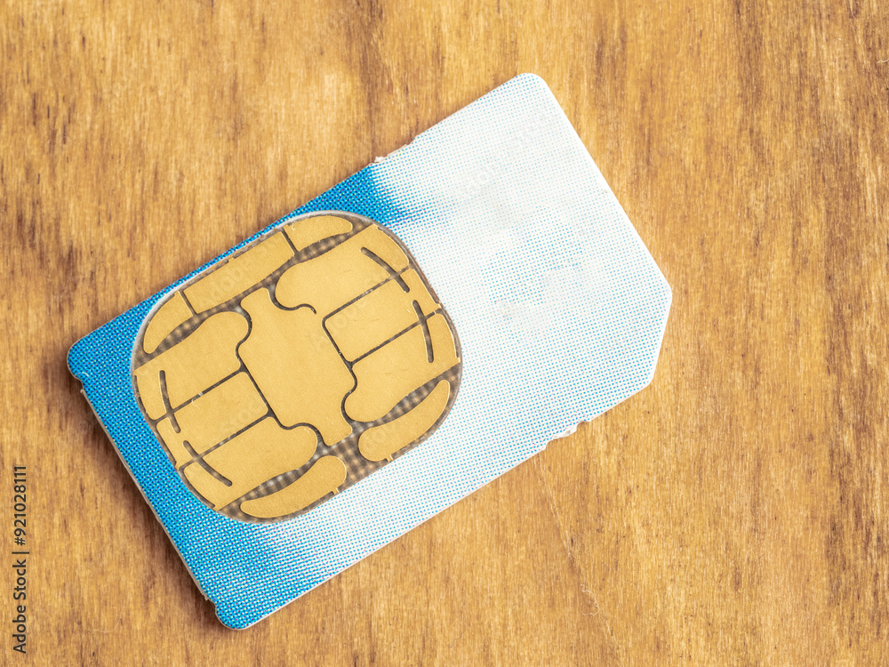 close up of a telecommunications smart phone sim card isolated on a wooden background close up of a telecommunications smart phone sim card isolated on a wooden background