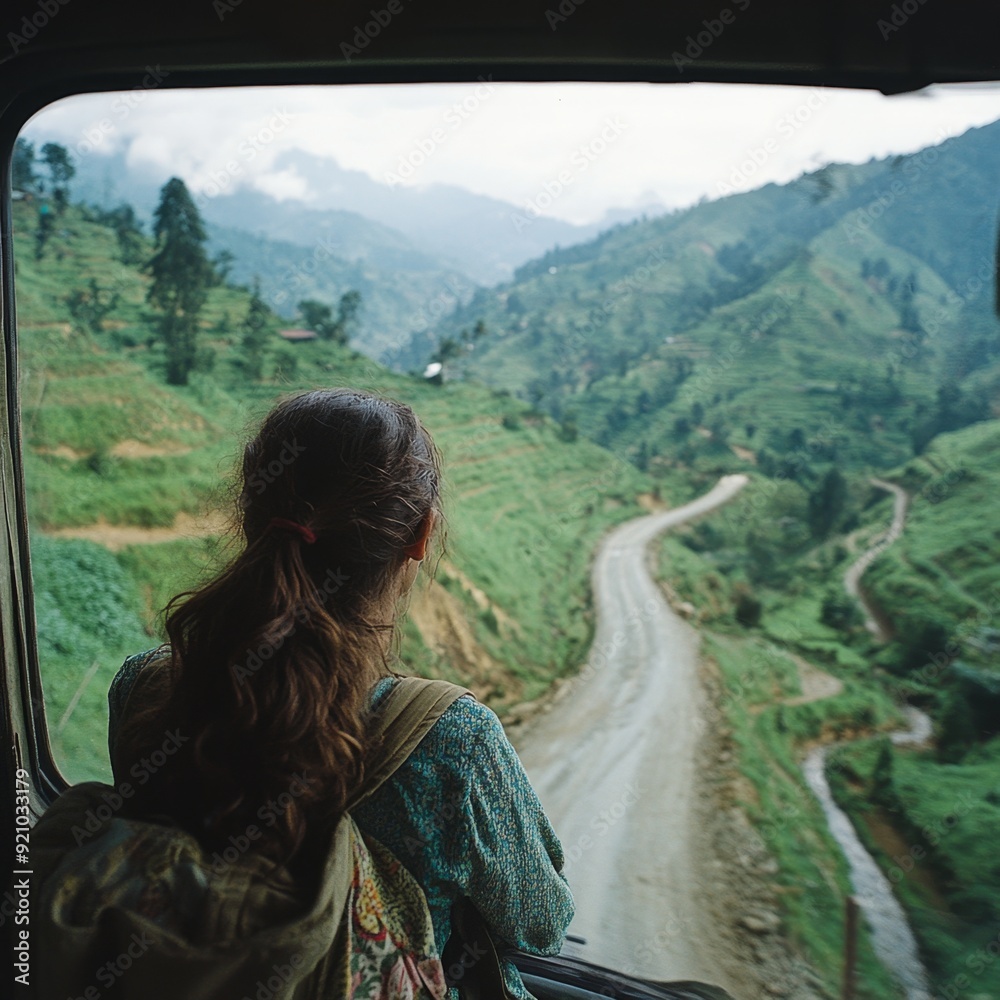Woman looking out of a bus window at a winding road in the mountains. Woman looking out of a bus window at a winding road in the mountains.