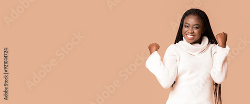 Photos Emotional winter black woman demonstrating happiness, clenching fists, got good
