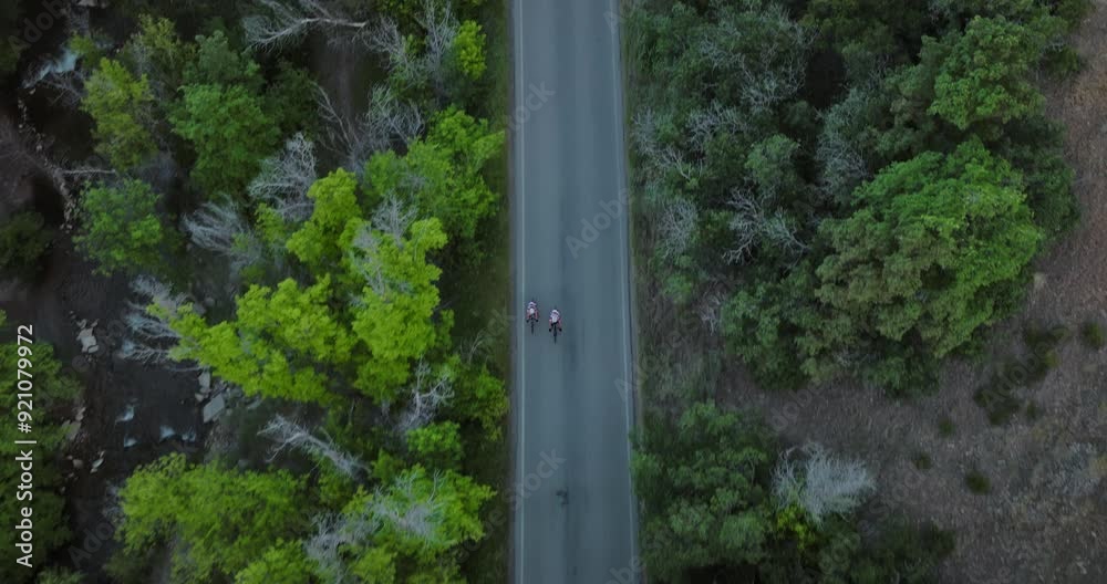 Two bikers on canyon road early in the morning - drone tilt shot Two bikers on canyon road early in the morning - drone tilt shot