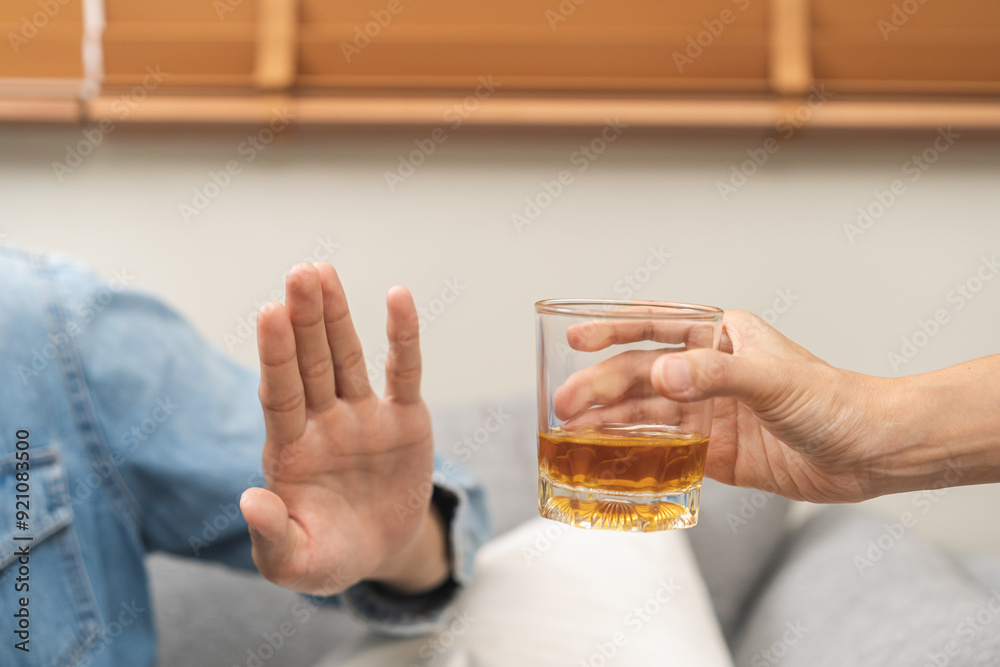 Alcoholism, depressed asian young man refuse, push out alcoholic beverage glass, drink whiskey, sitting alone at night. Treatment of alcohol addiction, having suffer abuse problem alcoholism concept. Alcoholism, depressed asian young man refuse, push out alcoholic beverage glass, drink whiskey, sitting alone at night. Treatment of alcohol addiction, having suffer abuse problem alcoholism concept.