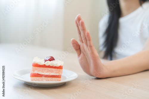 Diet asian young woman, girl hand push out, refuse eat piece chiffon strawberry layers cake, sweet or dessert taste, fighting to keep it from getting fat. Fast food unhealthy of weight loss concept. photo