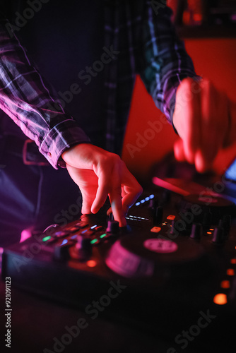 A close-up of the DJ's hands behind the console. 