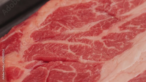 Fresh marbled beef with pepper, salt and rosemary close-up macro. Preparation to cook juicy steak on grill. Premium organic raw wagyu meat photo