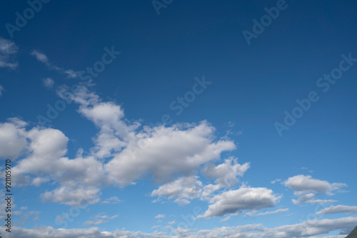 A vast, endless expanse of blue sky, dotted with fluffy, white clouds that look like cotton balls.