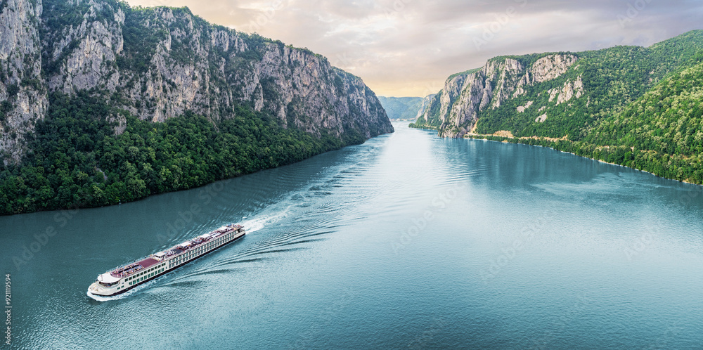 Passenger vessel cruising through the picturesque Iron Gate Gorge on a summer vacation trip