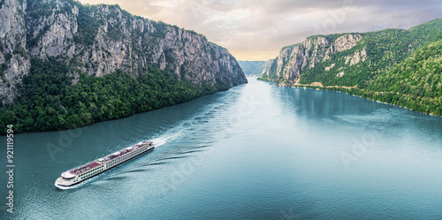 Obraz na płótnie Passenger vessel cruising through the picturesque Iron Gate Gorge on a summer vacation trip w salonie