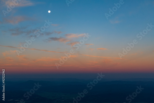 Sunset with the moon over mountains