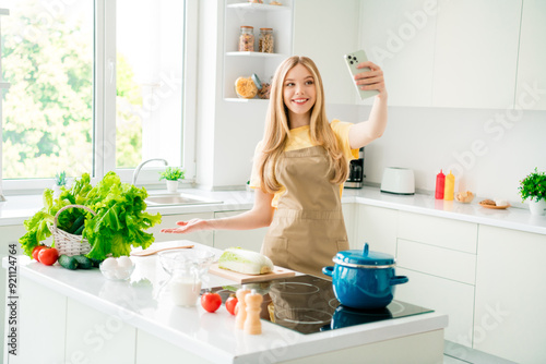 Photo of charming cheerful girl wife cooking meal showing recipe indoors house kitchen