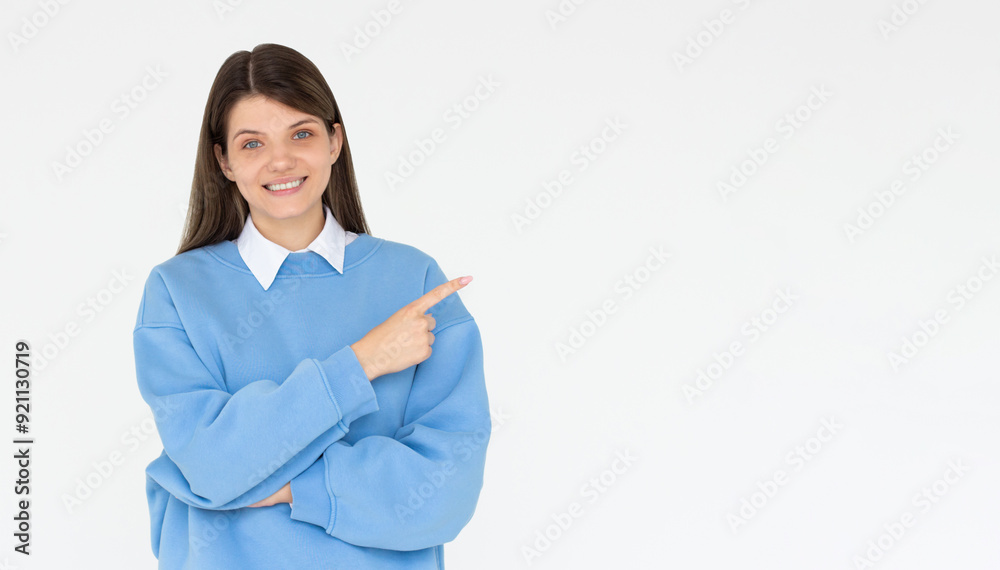 Hey look. Smiling pretty female model pointing fingers right at empty space and inviting to check it out, showing advertisement on white background. Hey look. Smiling pretty female model pointing fingers right at empty space and inviting to check it out, showing advertisement on white background.