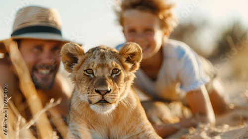 A father and child enjoy a special moment with a lion cub in a safari setting, creating unforgettable memories together amidst the wonders of the wild. photo