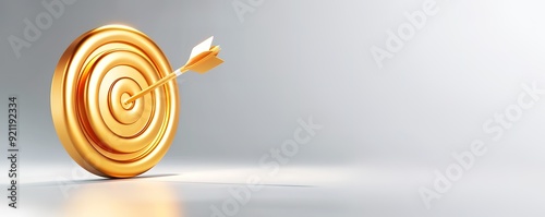 Gold dart arrow hitting the center of a gold target.  Conceptual image of success, achievement, and reaching goals.