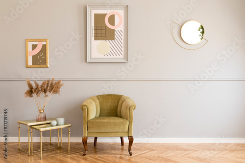 Stylish and luxury living room of apartment interior with elegant green armchair  retro table with flowers and chic accessories