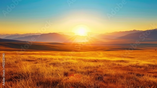 Distant Sunrise. Vivid Yellow Sunrise Over Dry Grassy Plains with Mountains in the Distance