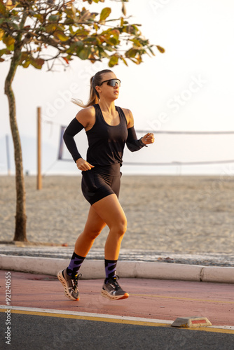 Woman running on the shore of Balneário Camboriú beach