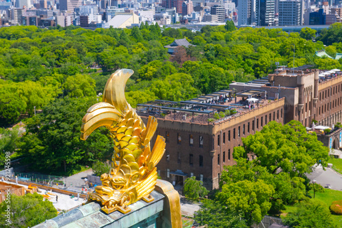 Osaka Castle Shachihoko (sea monster) on main keep roof. Osaka Castle is a Japanese castle in Chuo ward in historic city of Osaka, Japan. It's one of the most famous castle in Japan.  photo