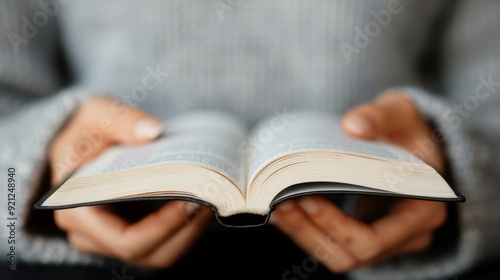 Hands on Open Book With Intricate Patterns in a Softly Lit Environment