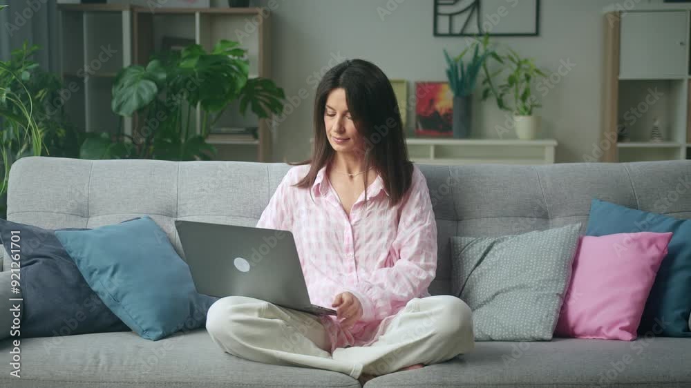 Cozy living room scene of woman working comfortably on laptop Cozy living room scene of woman working comfortably on laptop