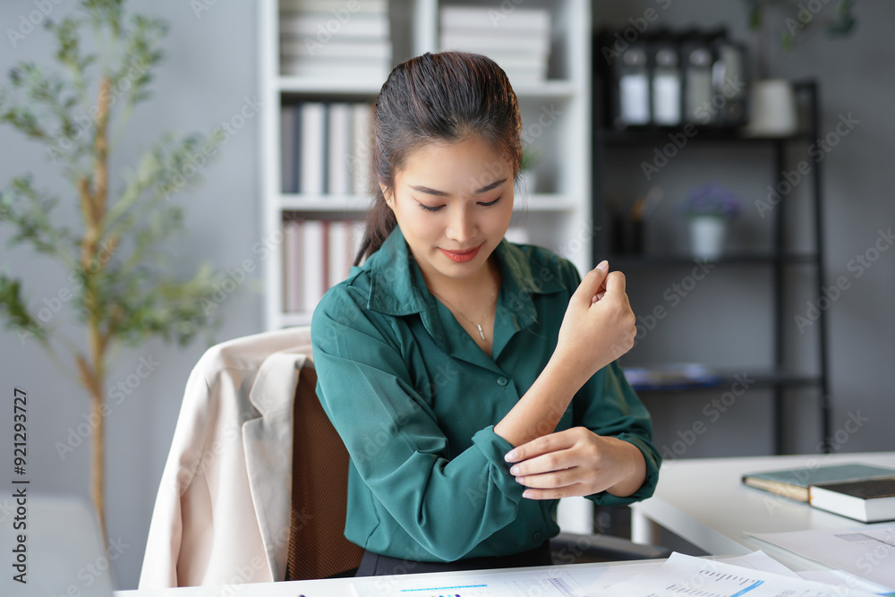 Businesswoman is rolling up her sleeves while sitting at her desk in the office, ready to tackle a new challenge Businesswoman is rolling up her sleeves while sitting at her desk in the office, ready to tackle a new challenge