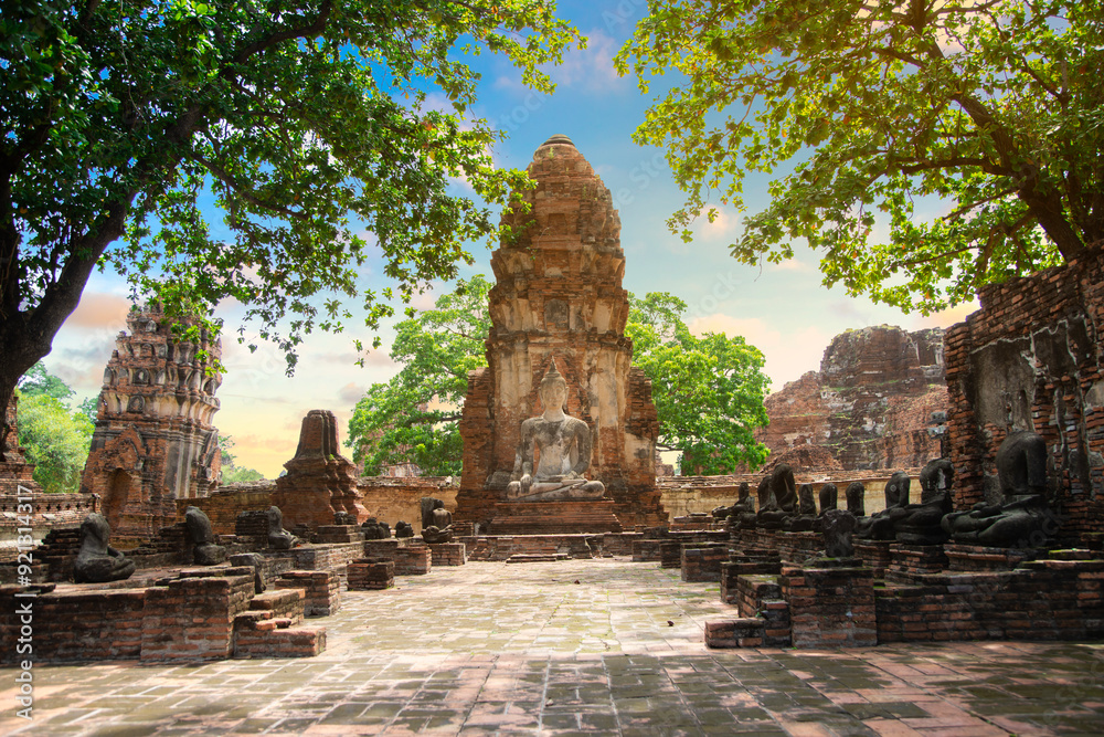 Naklejka premium Ruins of Buddha statues and pagoda in Wat Mahathat, the old Thai temple inside Ayutthaya historical park, Thailand