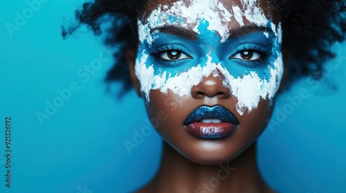 A striking image of a young woman with bold and artistic face paint in blue and white patterns, symbolizing creativity, expression, and the vibrancy of self-identity. photo