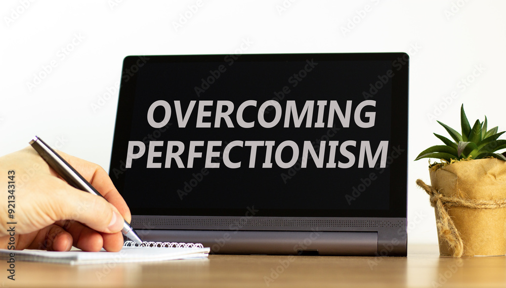 Overcoming perfectionism symbol. Concept words Overcoming perfectionism on beautiful black pad. Beautiful white background. Businessman hand. Business Overcoming perfectionism concept. Copy space. Overcoming perfectionism symbol. Concept words Overcoming perfectionism on beautiful black pad. Beautiful white background. Businessman hand. Business Overcoming perfectionism concept. Copy space.