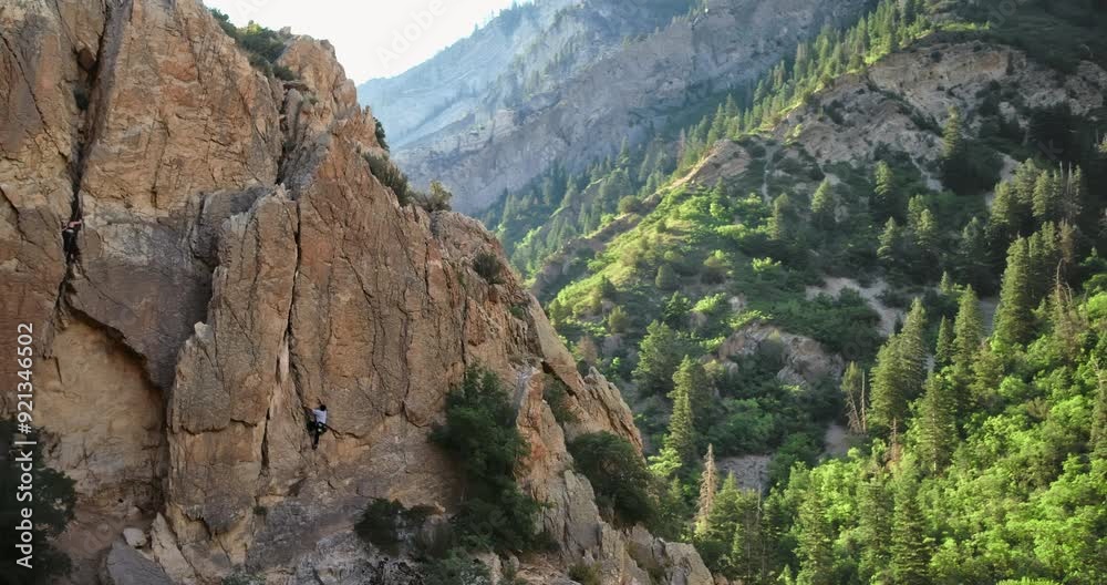 Beautiful wide, drone shot around rocky mountain at sunrise and climber Beautiful wide, drone shot around rocky mountain at sunrise and climber
