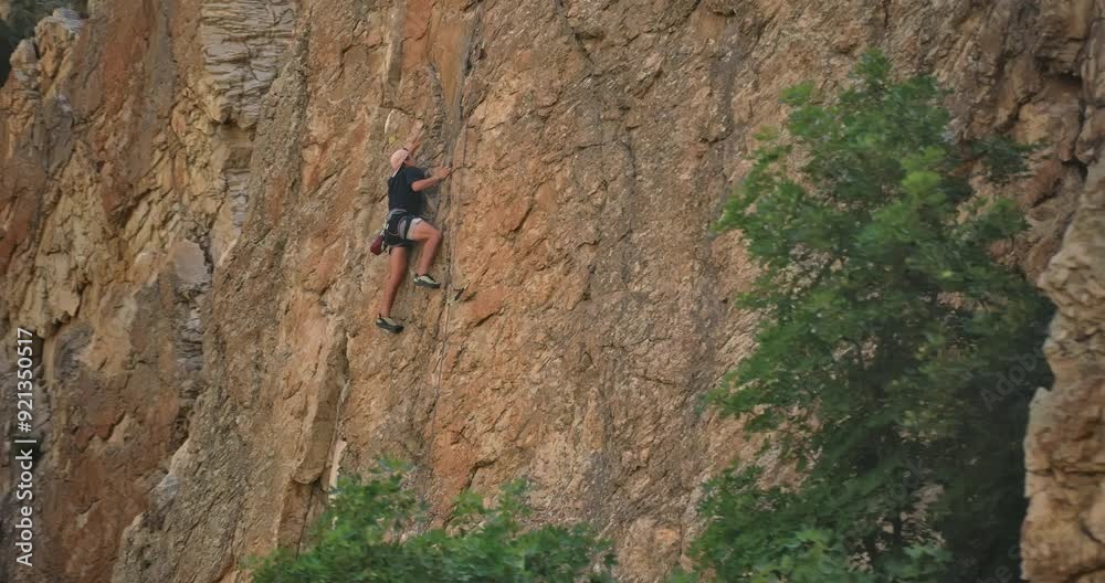 Young rock climber on dangerous rock wall - smooth drone shot Young rock climber on dangerous rock wall - smooth drone shot