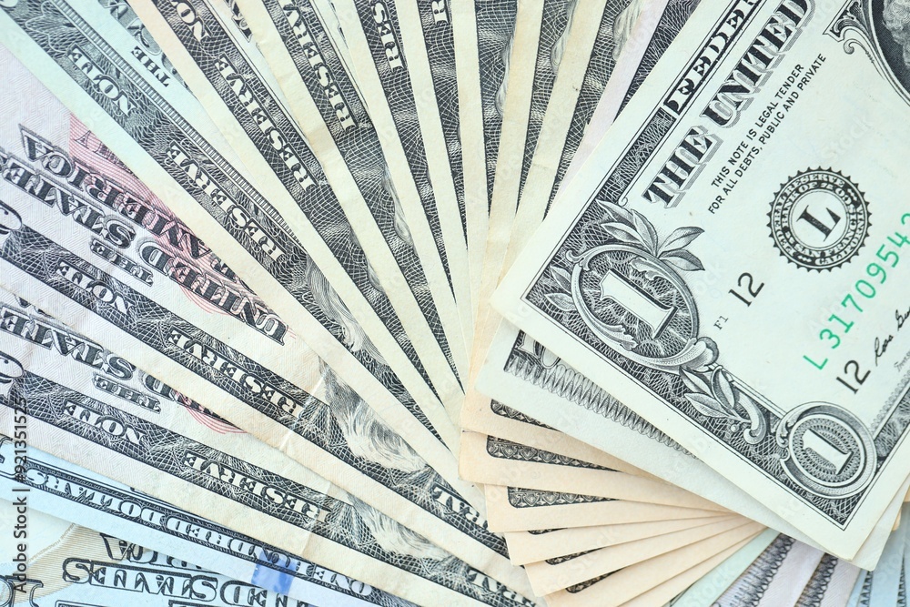 Many dollar bills with different nominations lies in big pile Many dollar bills with different nominations lies in big pile