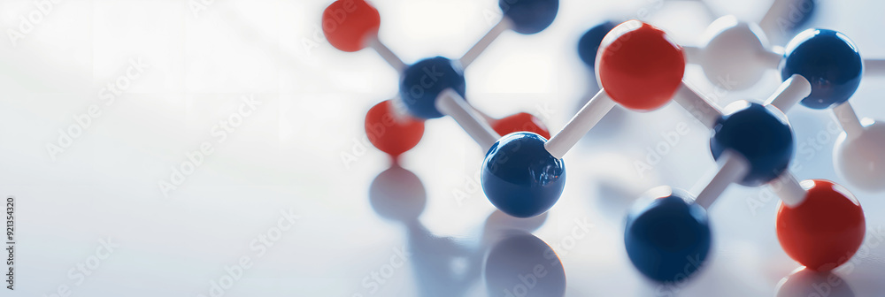 Science banner with close-up of molecular model kit on white surface, soft shadows, space for text