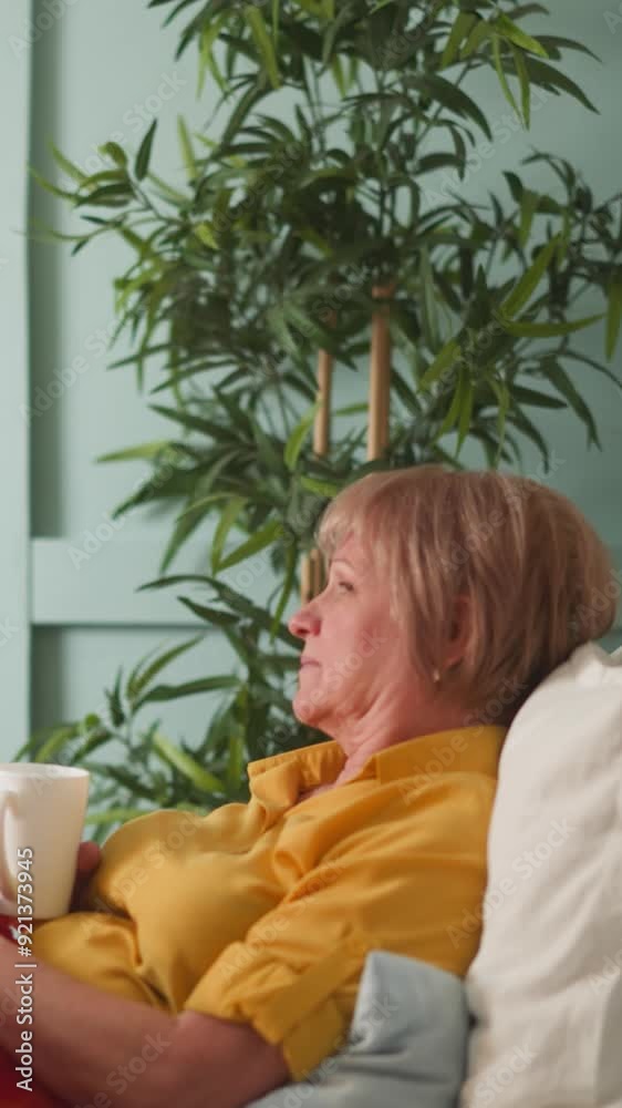 Pleasant daughter-in-law gives mother-in-law pills from jar and cup of tea. Old woman lying in bed on pillows suffering from high blood pressure Pleasant daughter-in-law gives mother-in-law pills from jar and cup of tea. Old woman lying in bed on pillows suffering from high blood pressure