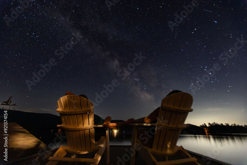 Milky Way rises over two Adirondack chairs