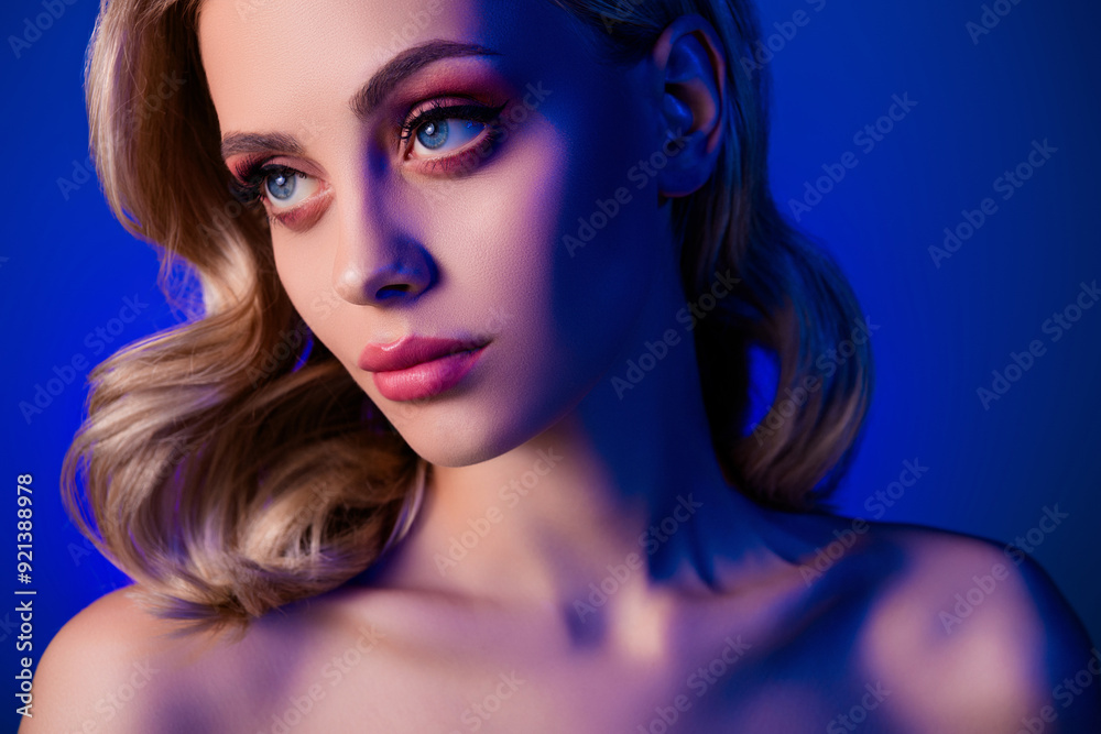 Photo of pretty girl with blonde hair curls look profile side isolated neon color blue background Photo of pretty girl with blonde hair curls look profile side isolated neon color blue background